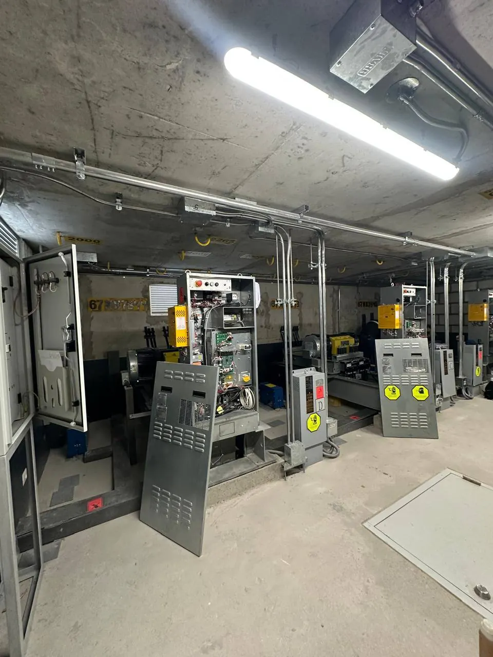 Sala de máquinas con tableros y equipos de elevación
